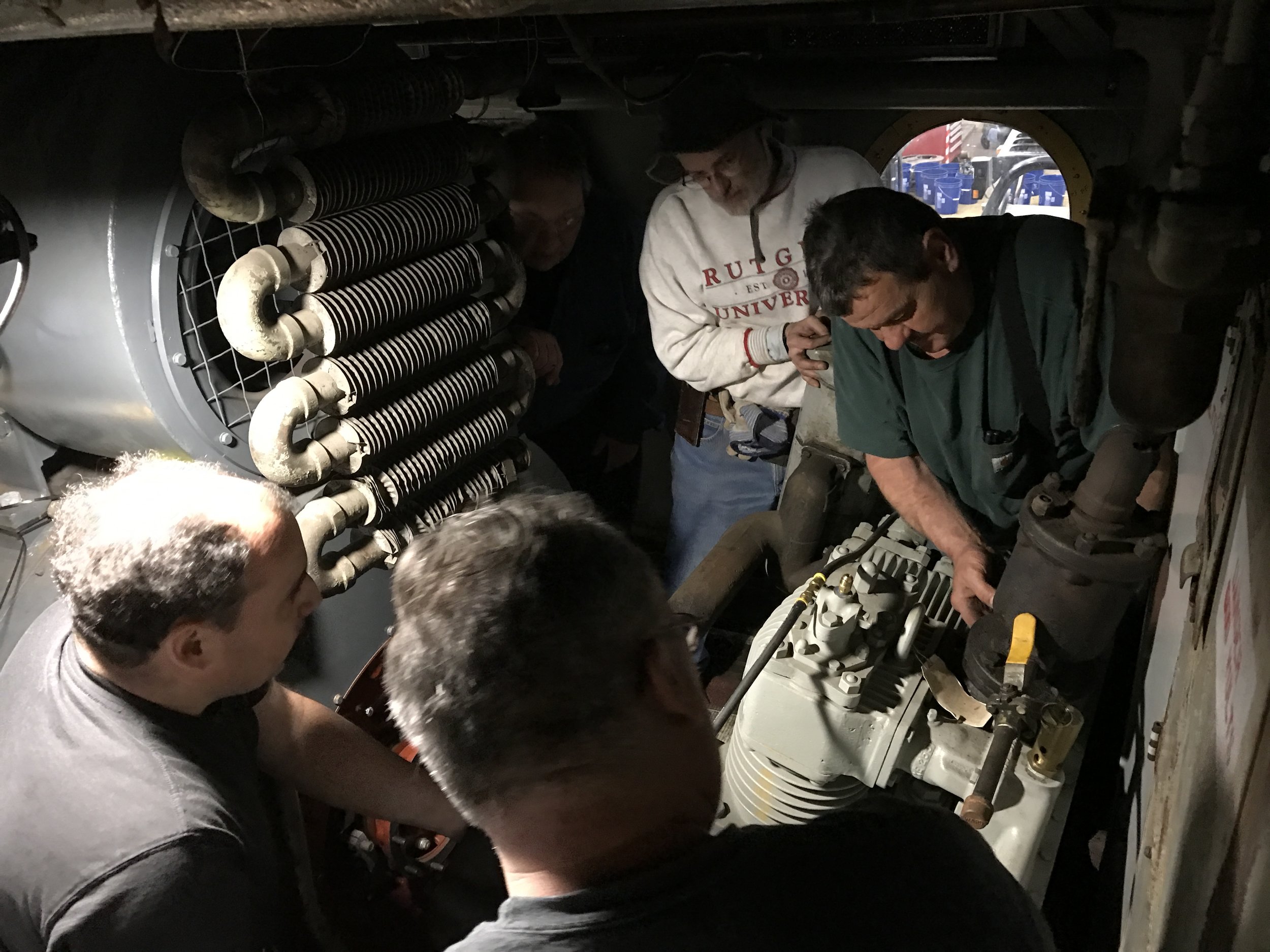  Volunteers and mechanics muscle the new compressor into place. 