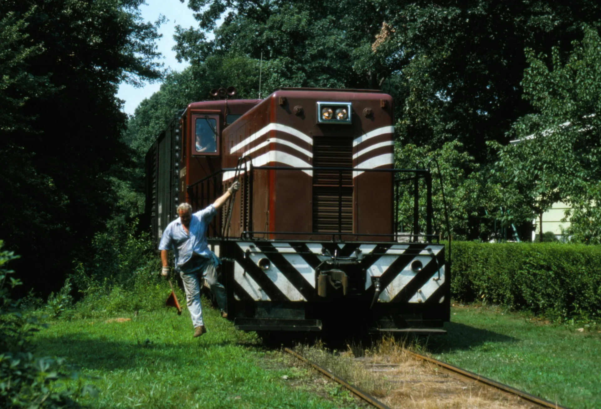 No. 16 trundles through Kenilworth on July 21, 1977 as Al Brooks drops off the engine to flag Faitoute Ave. Nos. 16 and 17 were repainted in 1976 into a matching Cornell red and white scheme. (Walter A. Appel photo)