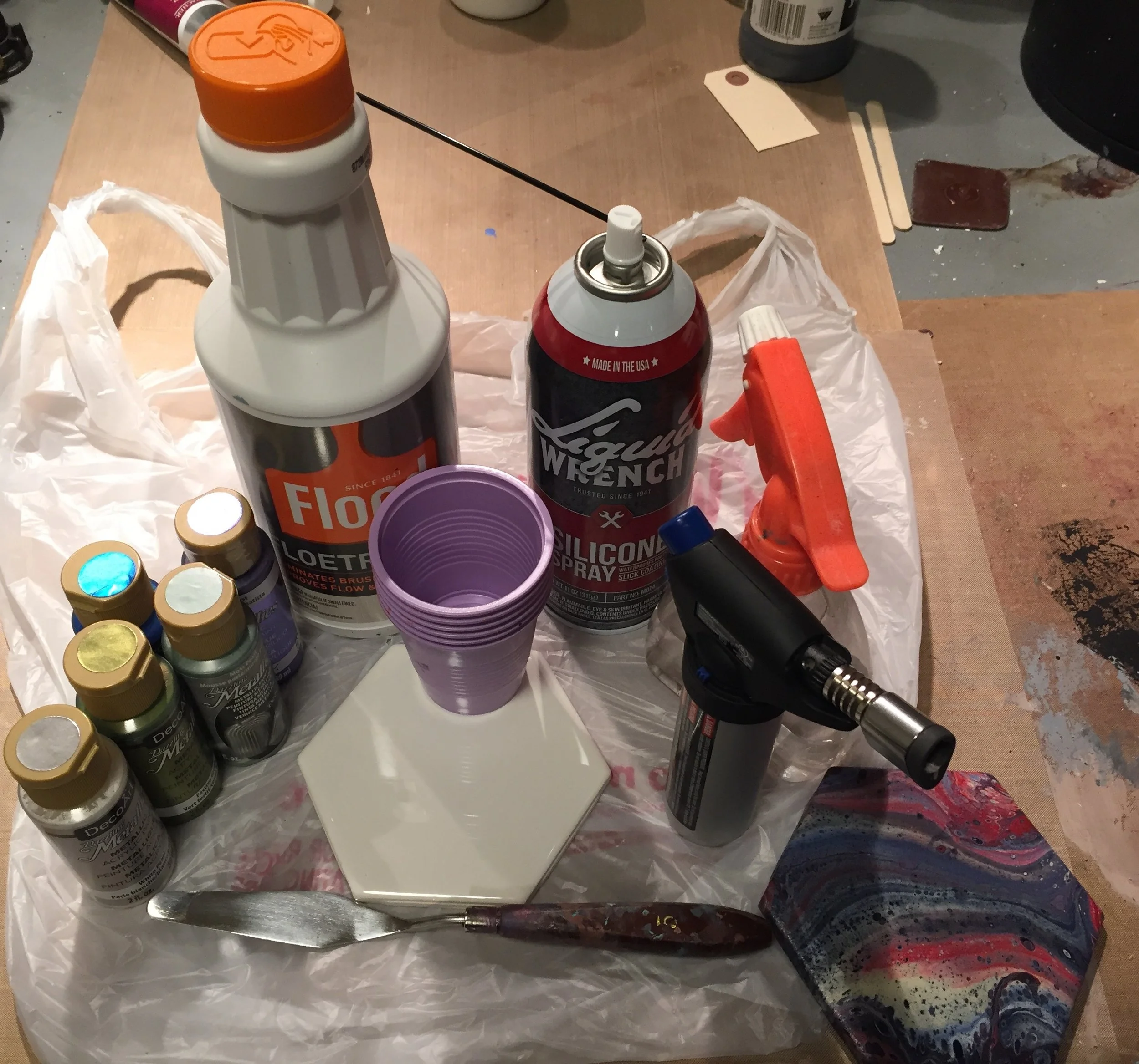 Acrylic Paint, Floetrol paint extender, disposable cups, ceramic tile, palette knife, 100% Silicone, water, torch. You will also need something to protect your work surface, stirring sticks (I use popsicle sticks) and paper towels. Disposable gloves also are recommended.