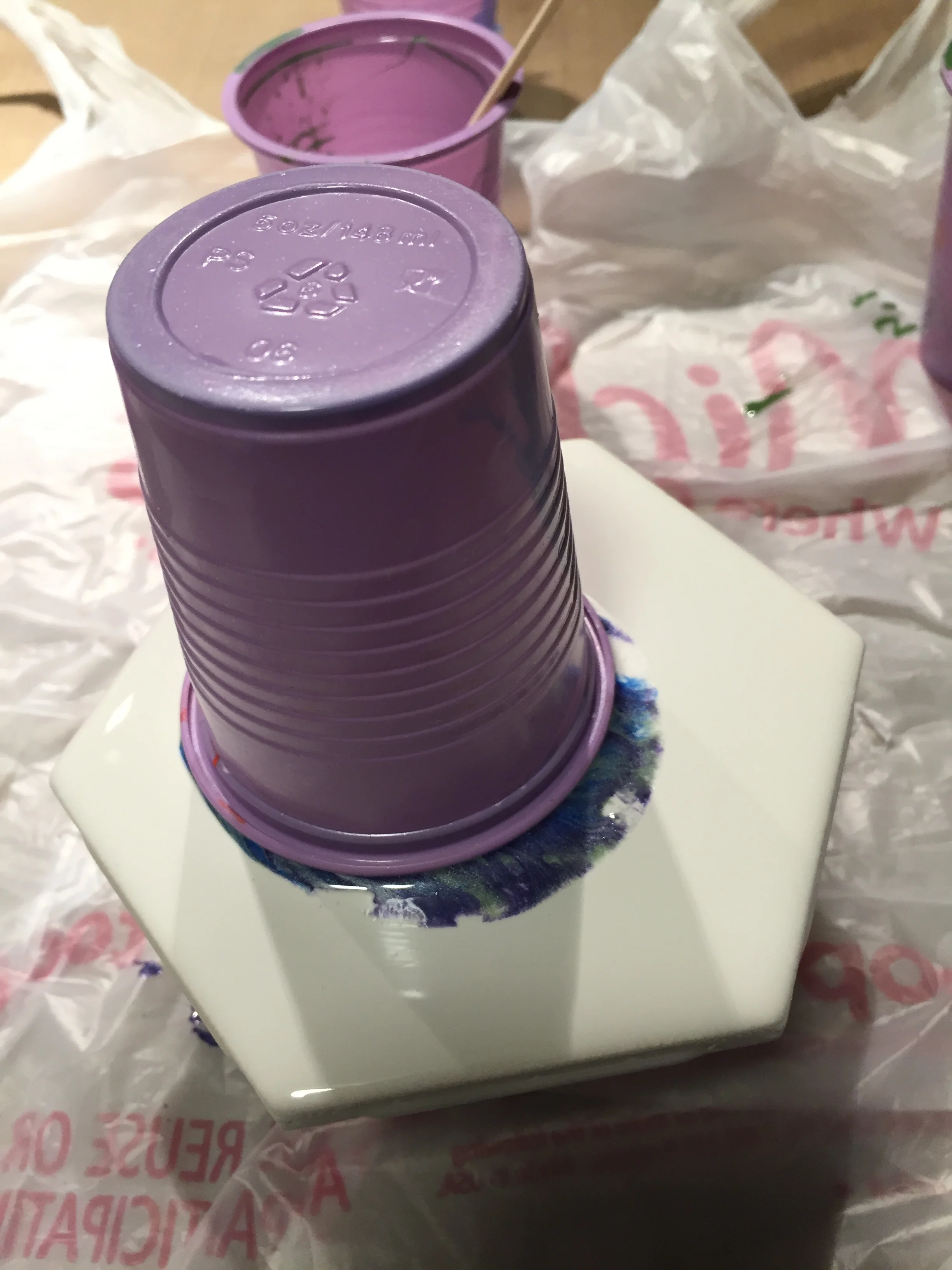 Hold your pour cup in the palm of your hand and place your substrate on top. Flip. Let the contents settle for a moment and then lift your cup. (I had taped a piece of wood to the bottom of my tile so that it was elevated while the paint ran over the sides). 