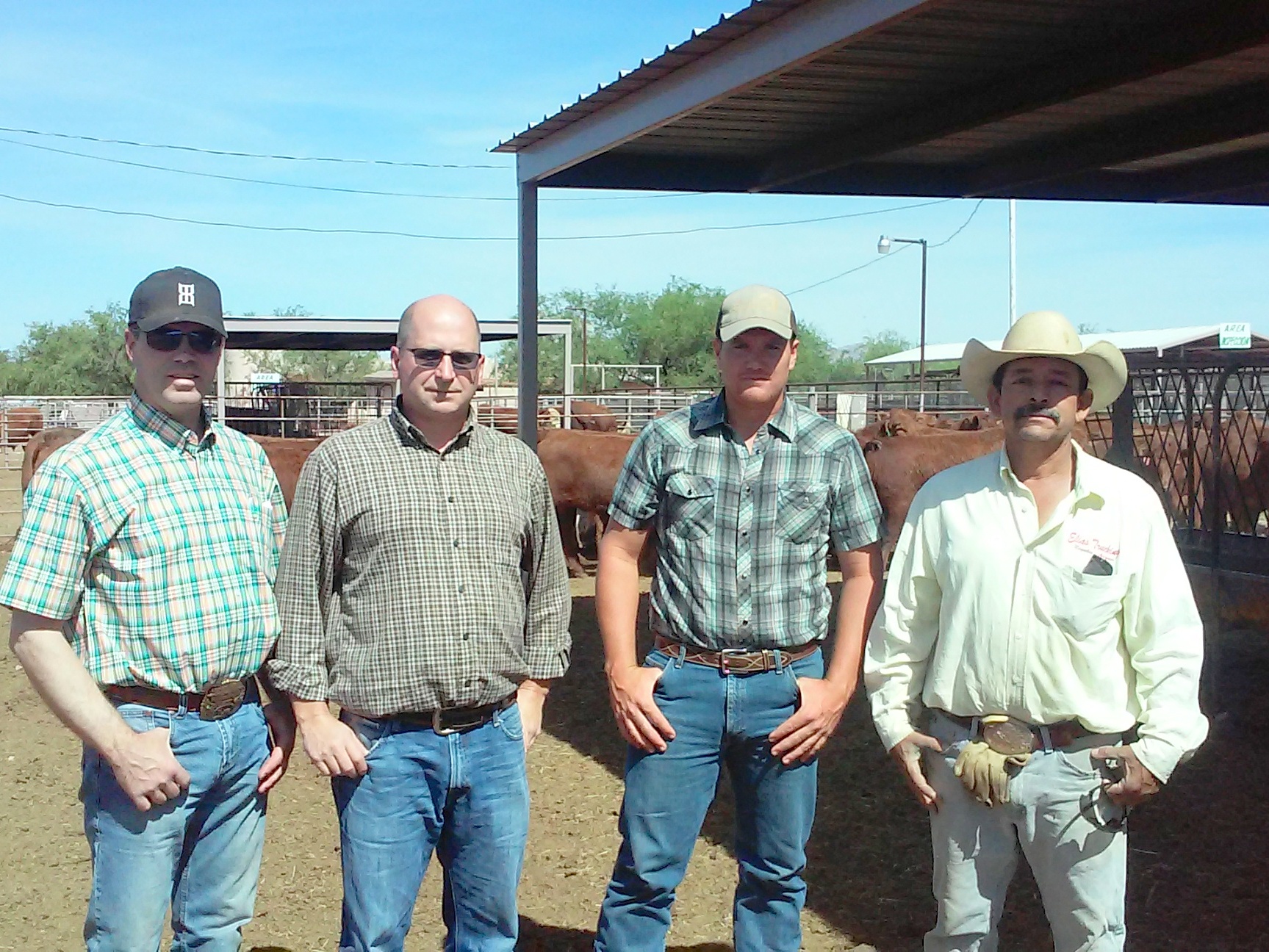 Troy (trucker), Duane, and Joel talk with the ranch hand at the holding pens.