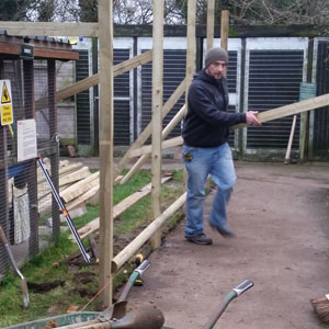 Volunteer Peter makes a valiant attempt to find the  pole vault as he specs out the design of the new barriers