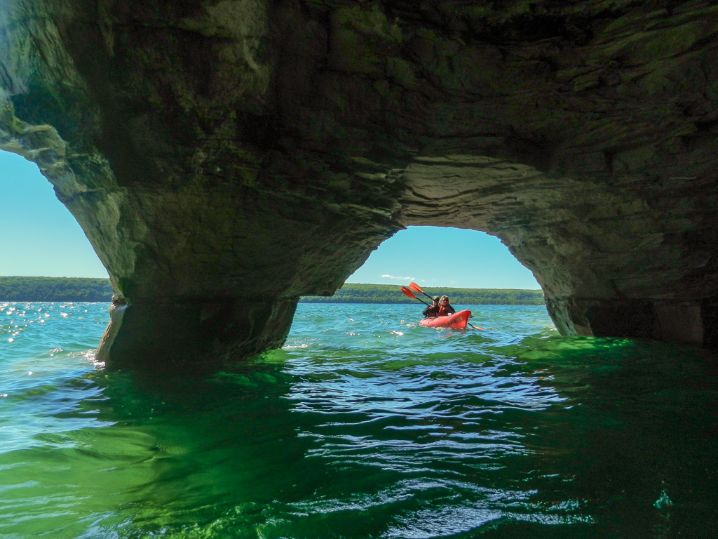 Paddling through an archway carved into the sandstone cliffs during our Classic expedition.