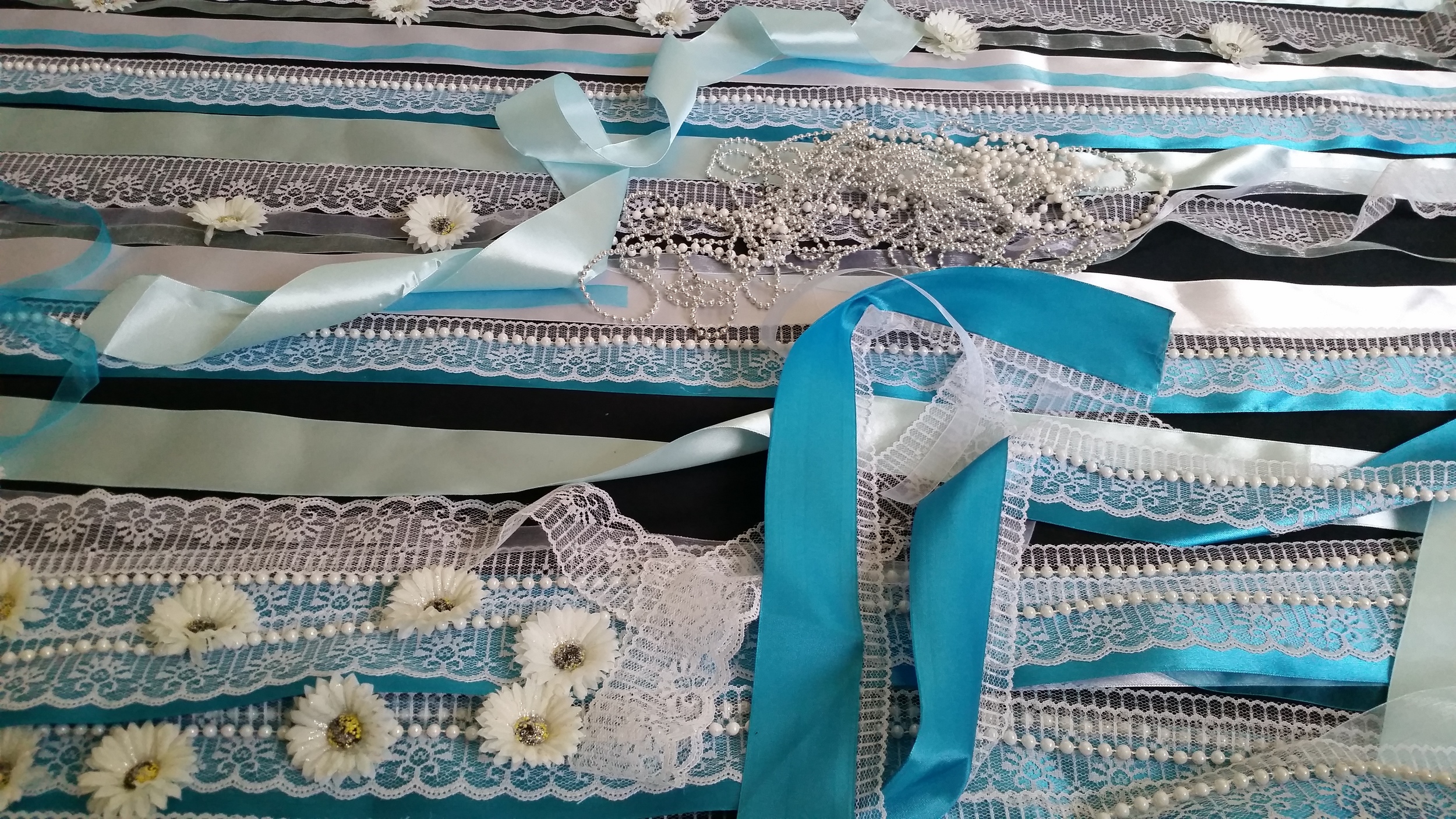 I embellished the satin ribbons with lace, pearls, silver beads and white daises.
