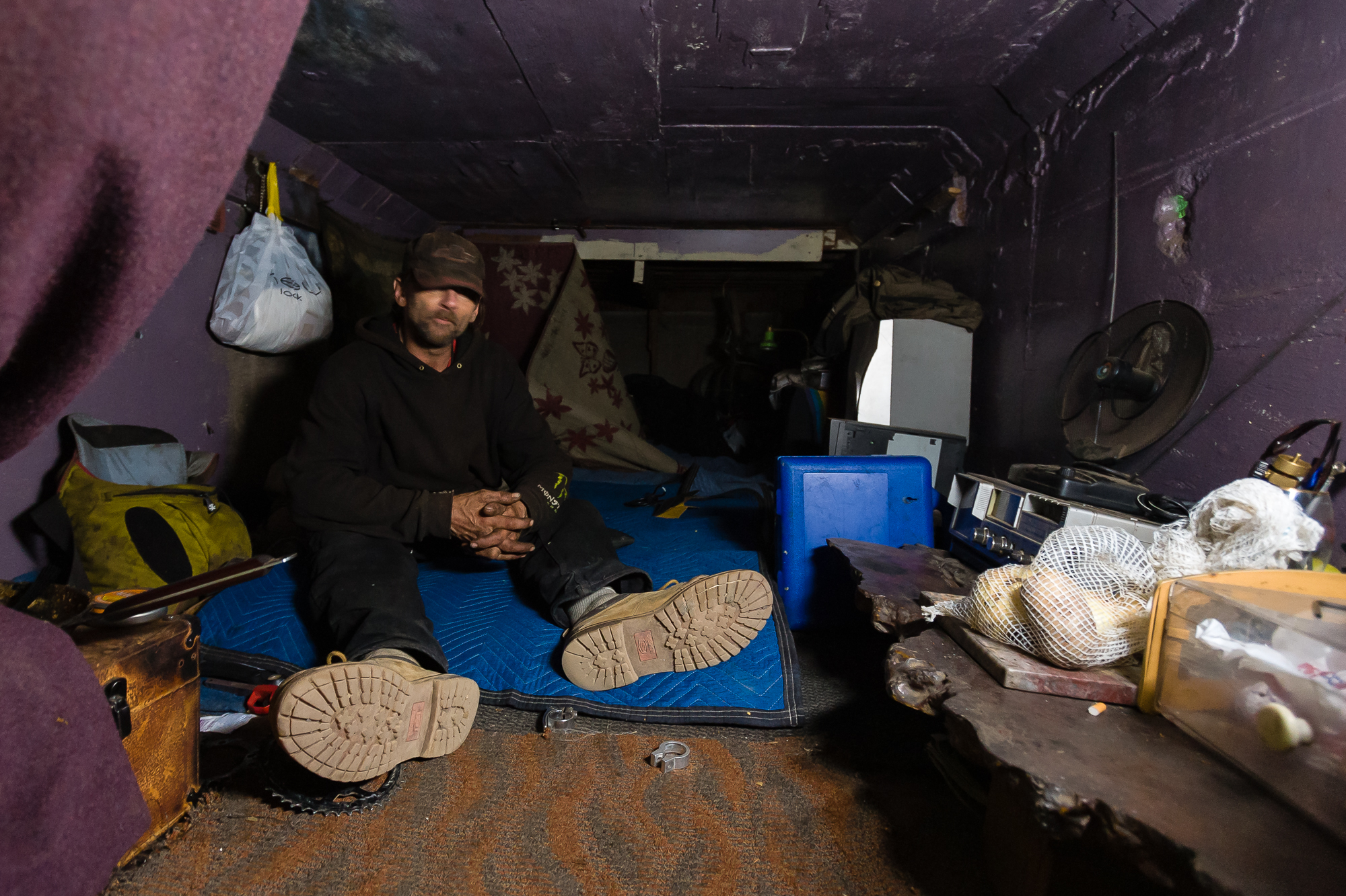  Inside a 4'x4'x20' crawl space, Steve keeps his area very tidy. He says today was a messy day for him. His space is wired with electricity, powering his light and radio. The space rattles continuously as cars pass by overhead. 