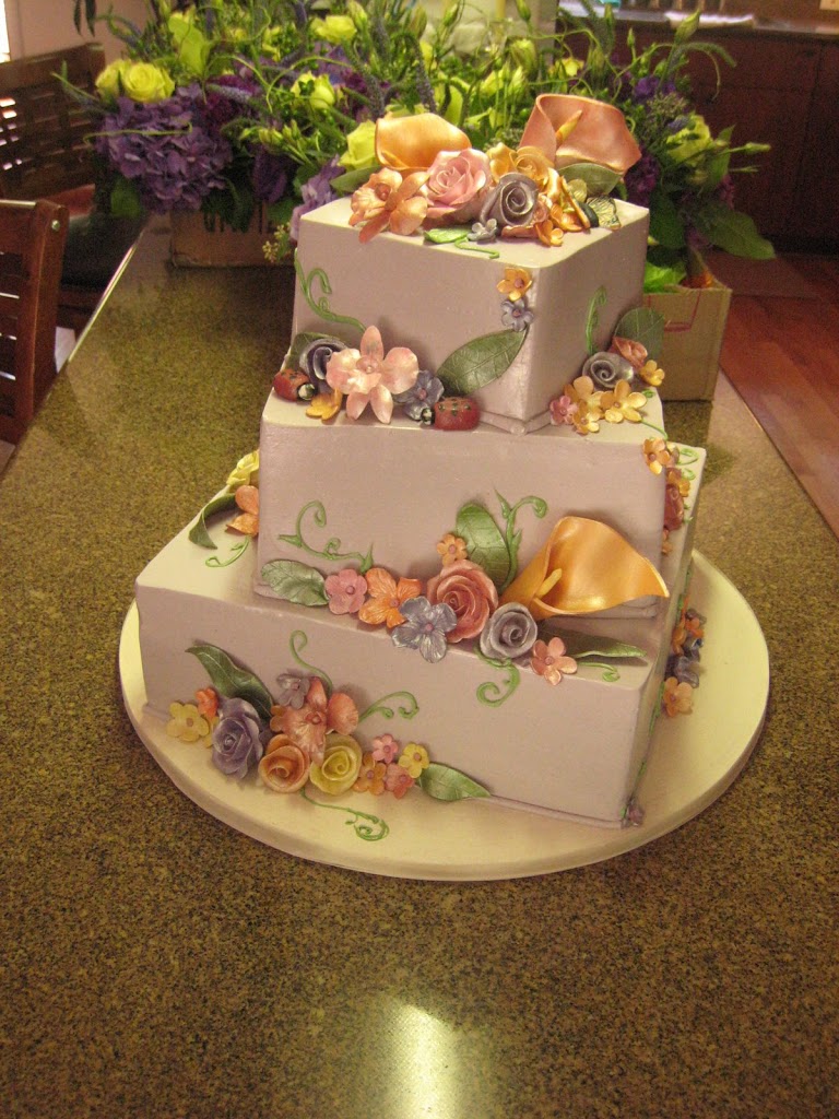 This fun wedding cake was iced in a lavender buttercream and covered with handmade sugar flowers