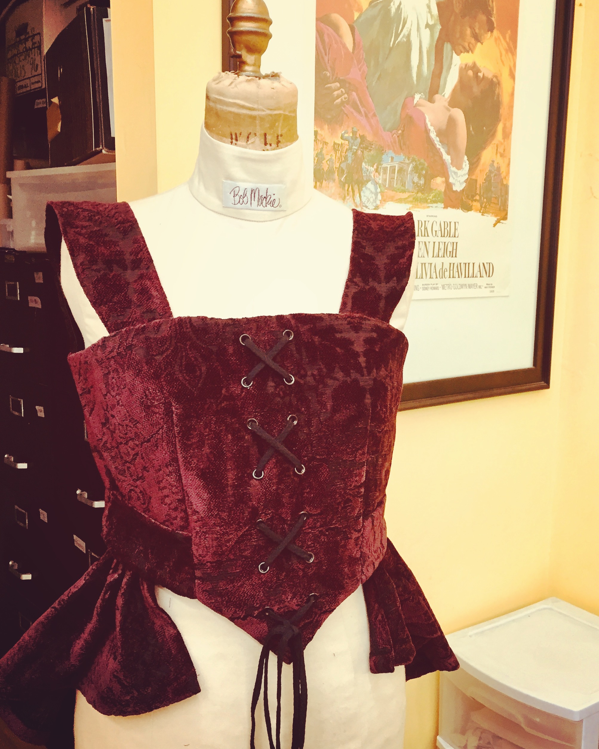 Corset with faux lace up front, side pockets, & peplum.