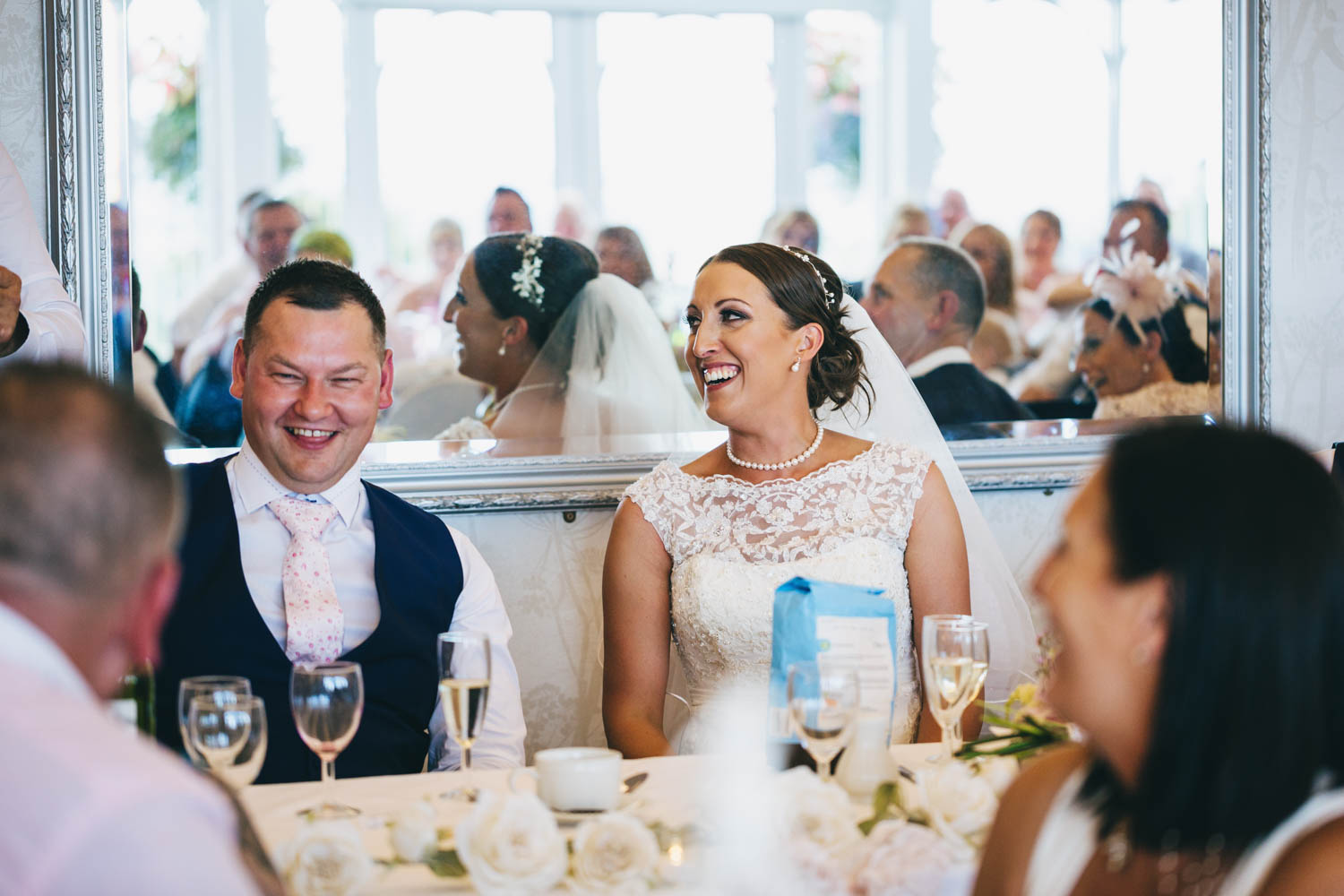 Bride and groom laughing at the speeches in the New house country hotel, thornhill, cardiff with south wales wedding photographer 