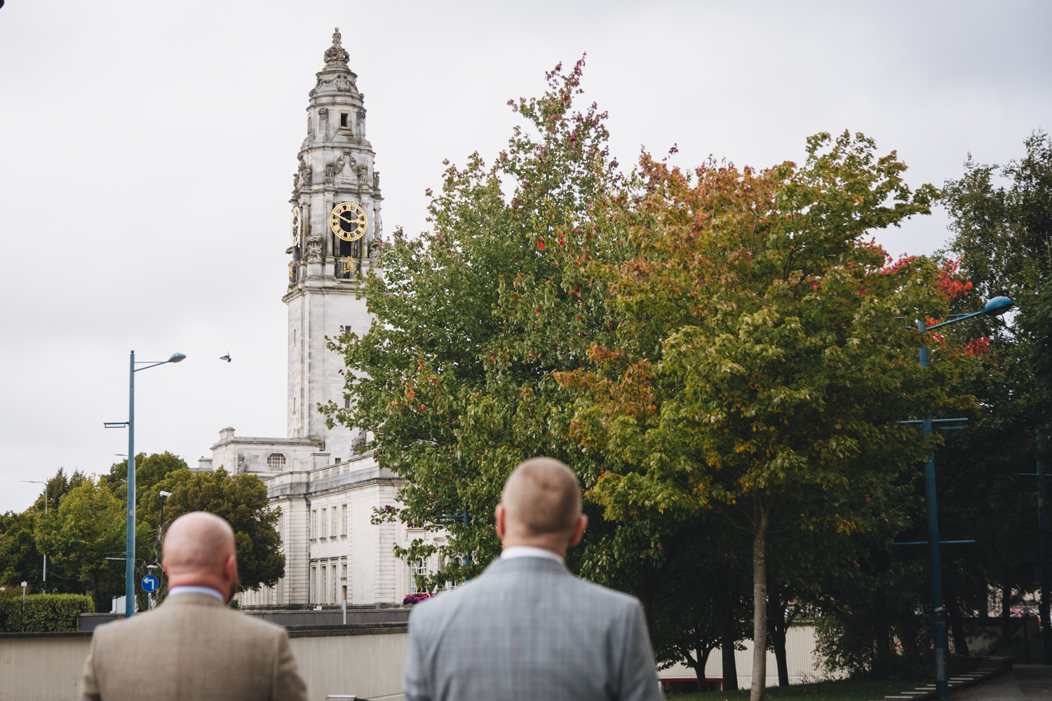 2 grooms walking towards their gay wedding ceremony at cardiff city hall with gay friendly south wales wedding photographer