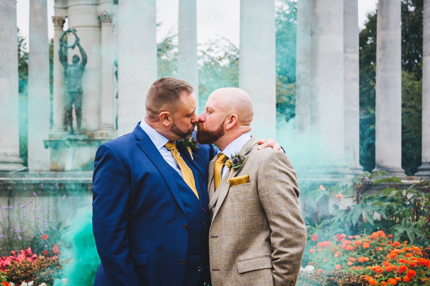 grooms kissing with smoke bomb at cardiff city hall and museum with gay friendly south wales wedding photographer