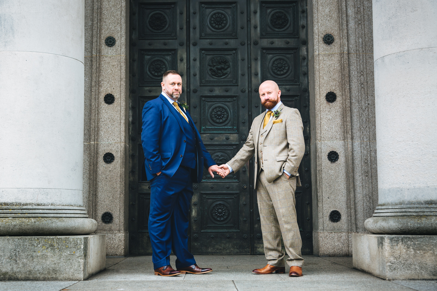 grooms holding hands at cardiff city hall and museum with gay friendly south wales wedding photographer