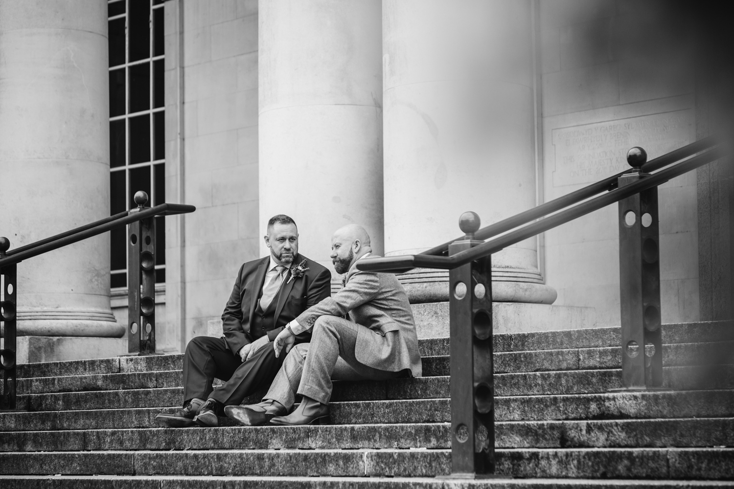 2 grooms on cardiff museum steps at Park Plaza Hotel Cardiff with gay friendly south wales wedding photographer