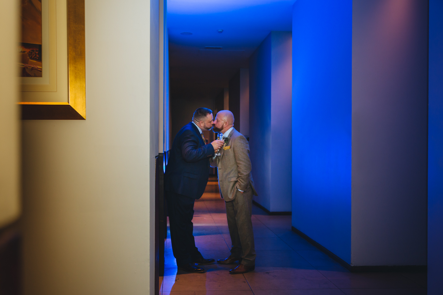 Blue gel back lit portrait of 2 grooms at Park Plaza Hotel Cardiff with gay friendly south wales wedding photographer