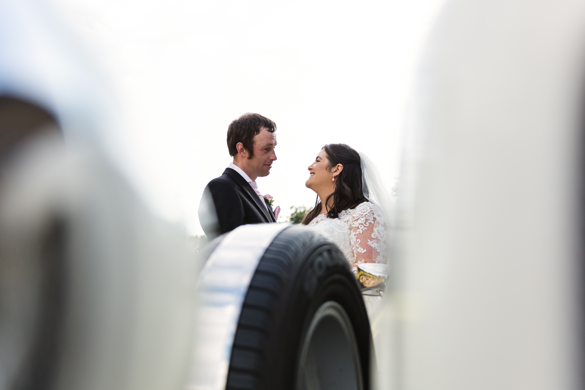 bride and groom portrait with wedding car at St Martins church Caerphilly
