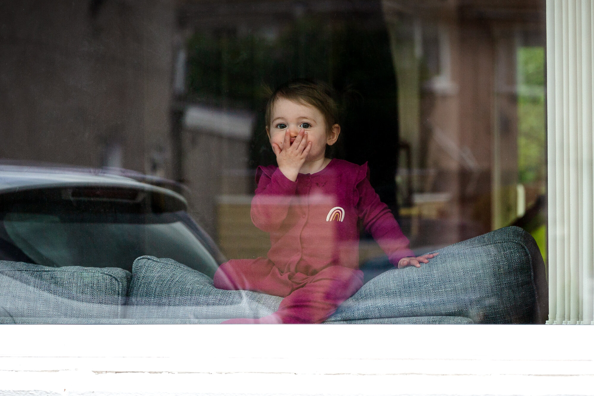 kisses brown through the window during the doorstep portrait challenge in covid 19