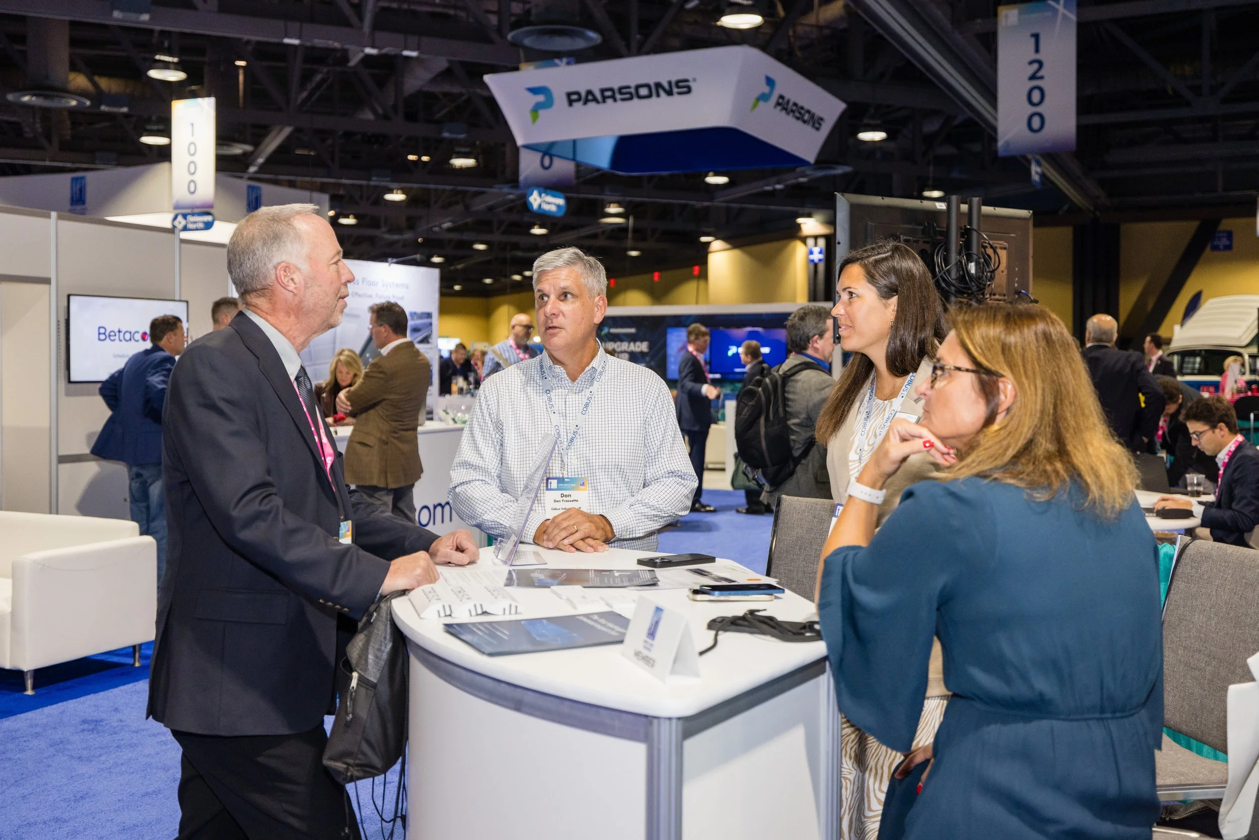 People engaging in a discussion at a trade show booth in an exhibit hall at a large trade association annual conference, sold and managed by Show Management Solutions.