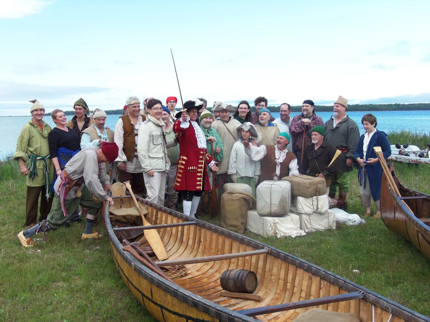 Reid Lewis, reprising his role as the Sieur de La Salle, brandishes a sword on the shore of Lake Michigan in June 2013. He is surrounded by fellow 20 th century voyageurs and their children and by French officials. The author is standing at far left. 