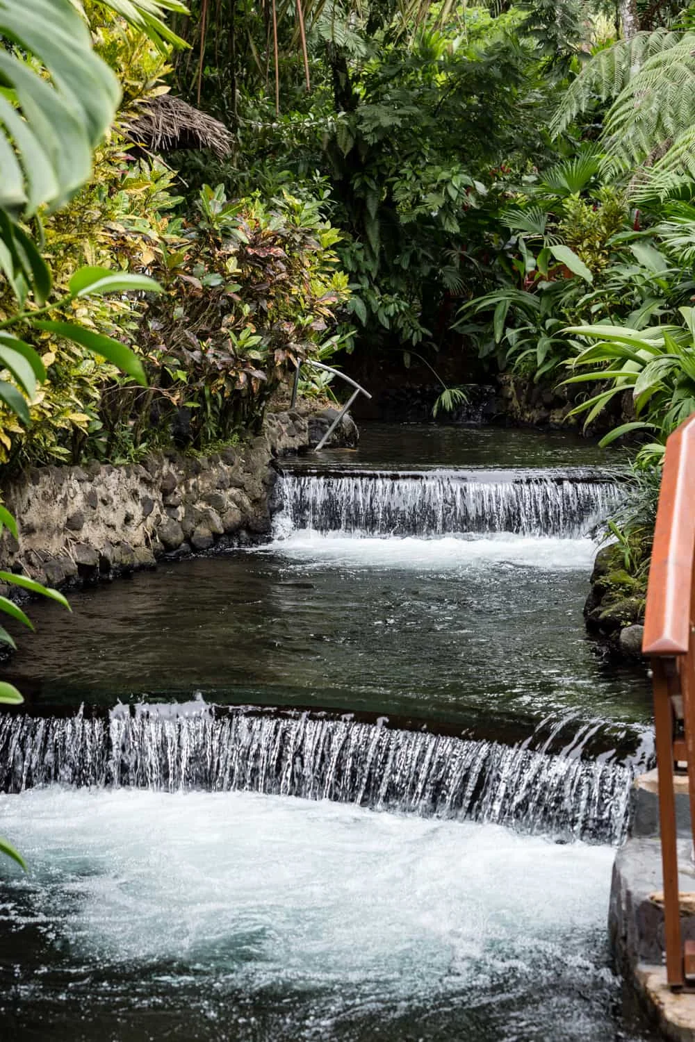 Water from Arenal thermal springs cascades over picturesque waterfalls at Tabacon Resort.