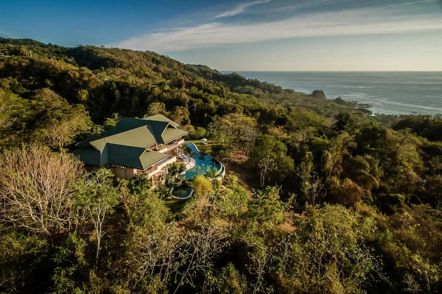 Arial view of Villa Nimbu nestled in rainforest with the Pacific Ocean in the background.