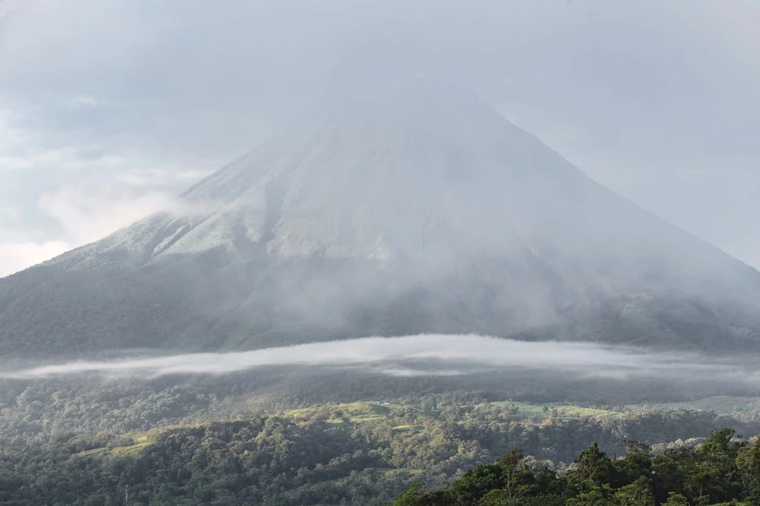 A view of the Arenal Volcano in La Fortuna enveloped in haze as seen from a guest suite at The Springs Resort & Spa.