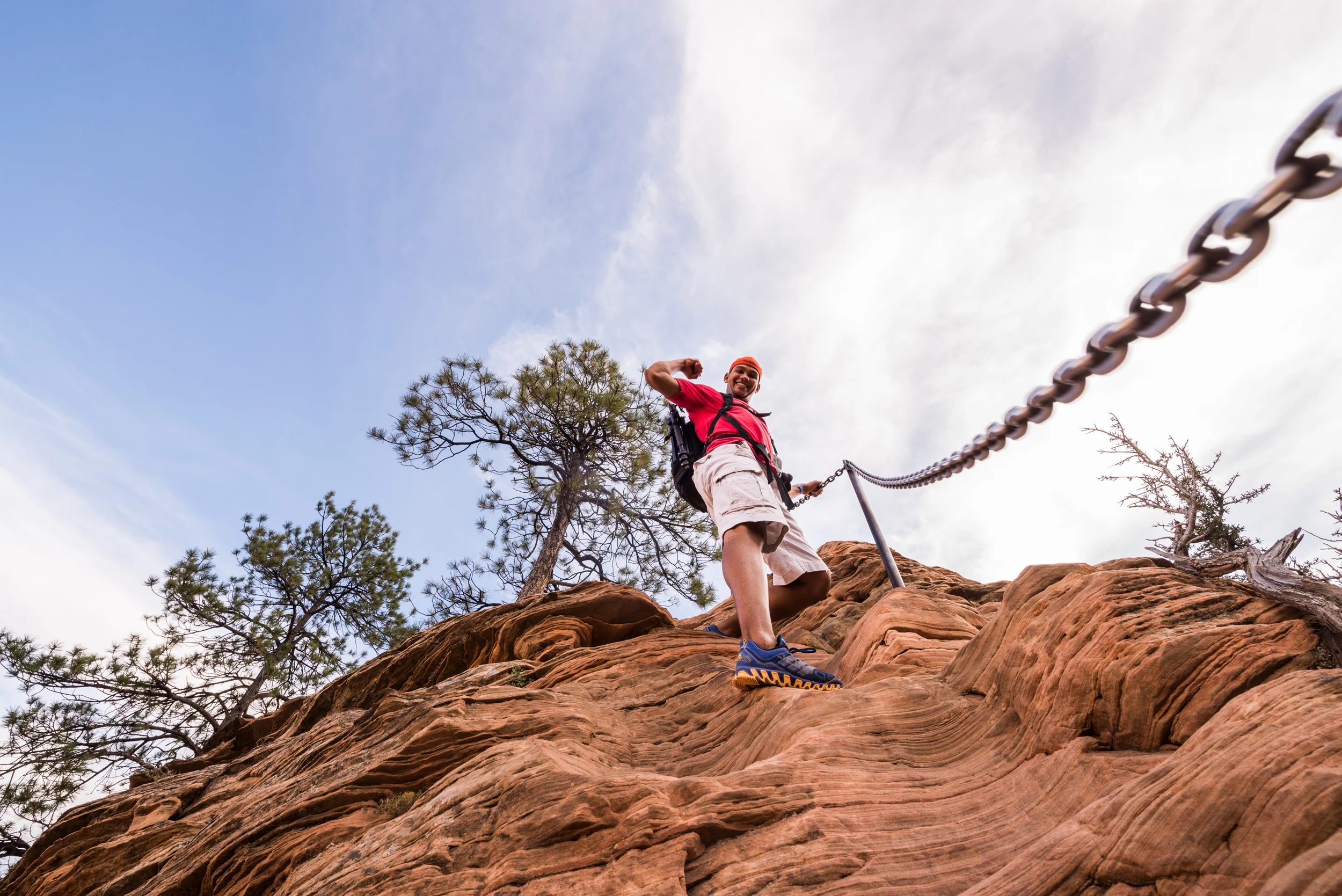Justin hikes up a steep portion of the trail, using the chain for support.