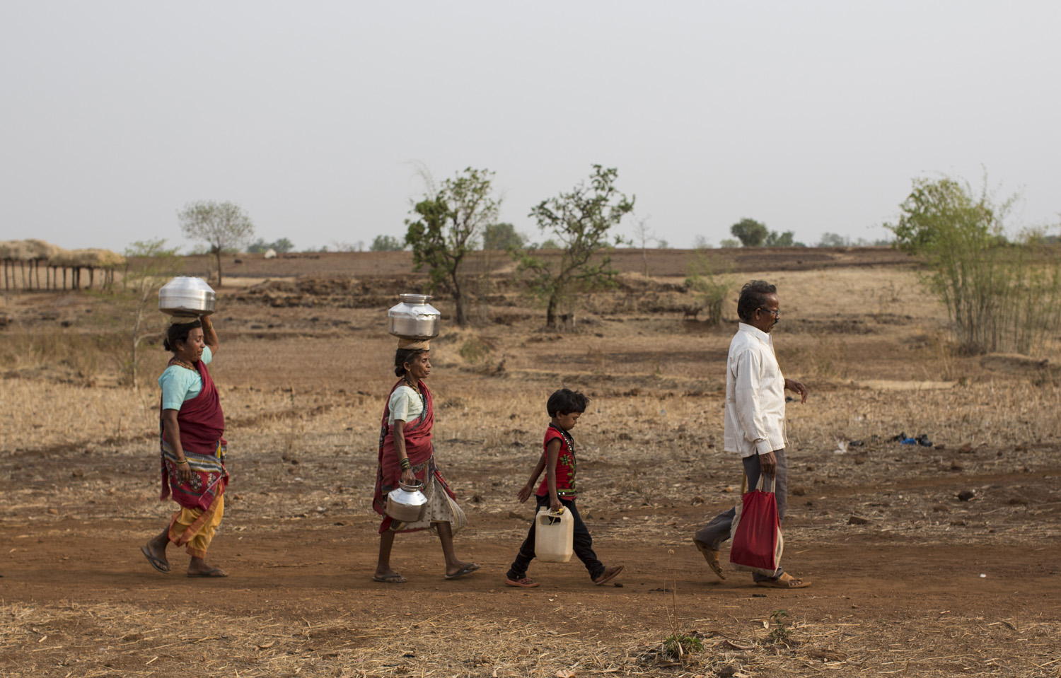  Bhaagi and Sakhri, wives of Sakharam Bhagat walk to fetch water from a well outside Denganmal village. 