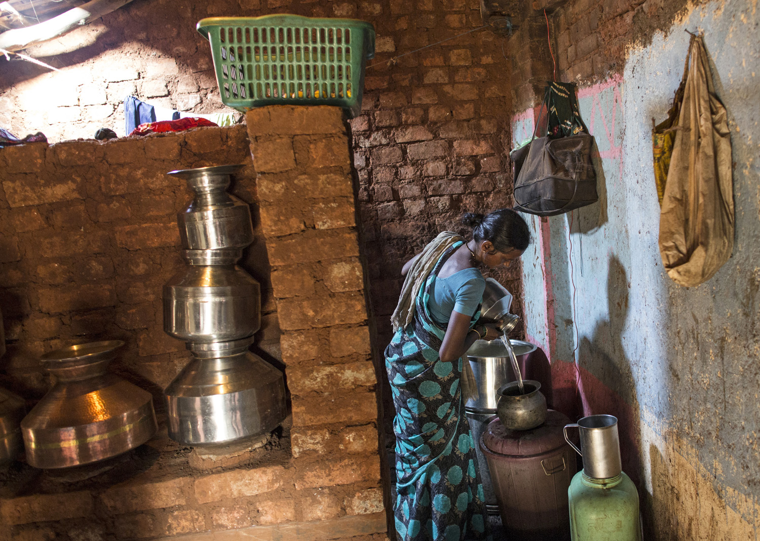  Shivarti, second wife of Namdeo, empties a water pitcher as she gets ready to fill water from a well outside Denganmal village. 