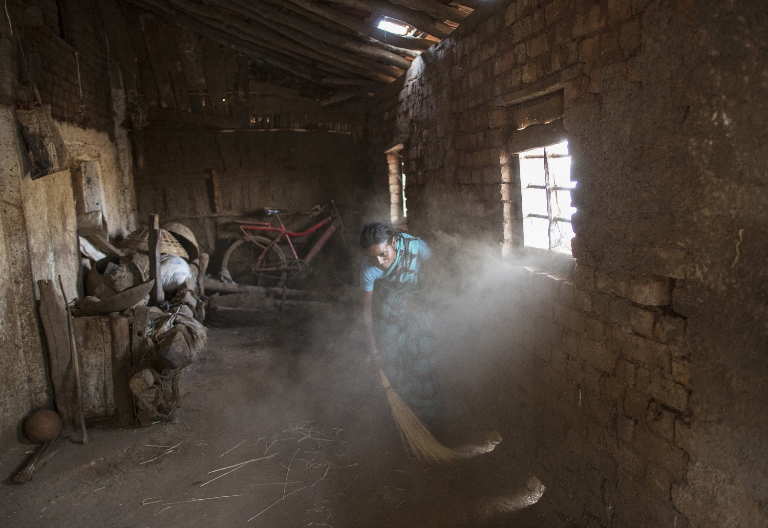  Shivarti, second wife of Namdeo, cleans a room inside their house in Denganmal village. 