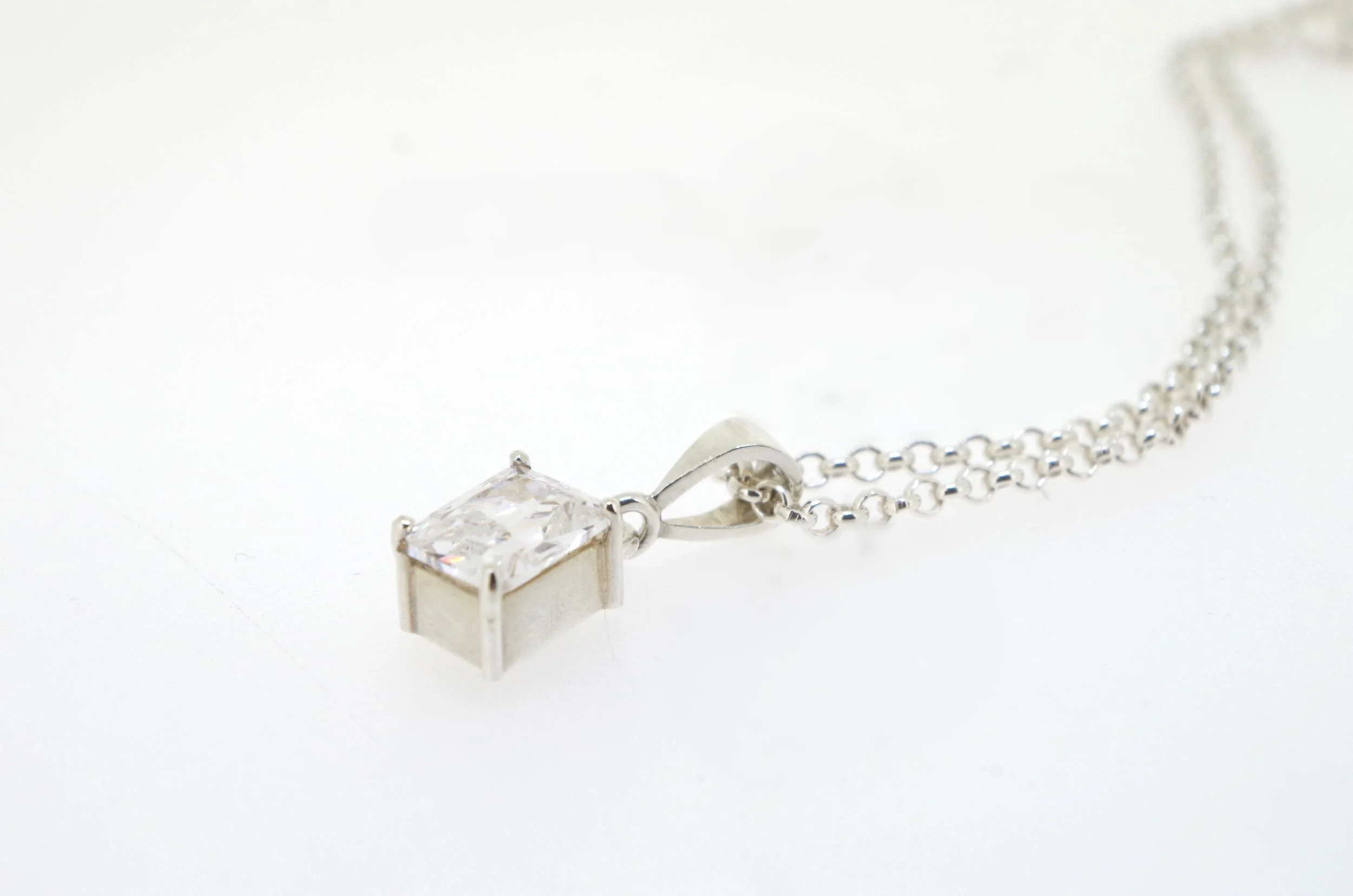  This pendant was made in my own time as part of a personal undertaking of work experience at an independent jewellery gallery and workshop in Perth, Western Australia. The pendant is sterling silver and is set with a rectangular cubic zirconia. The 