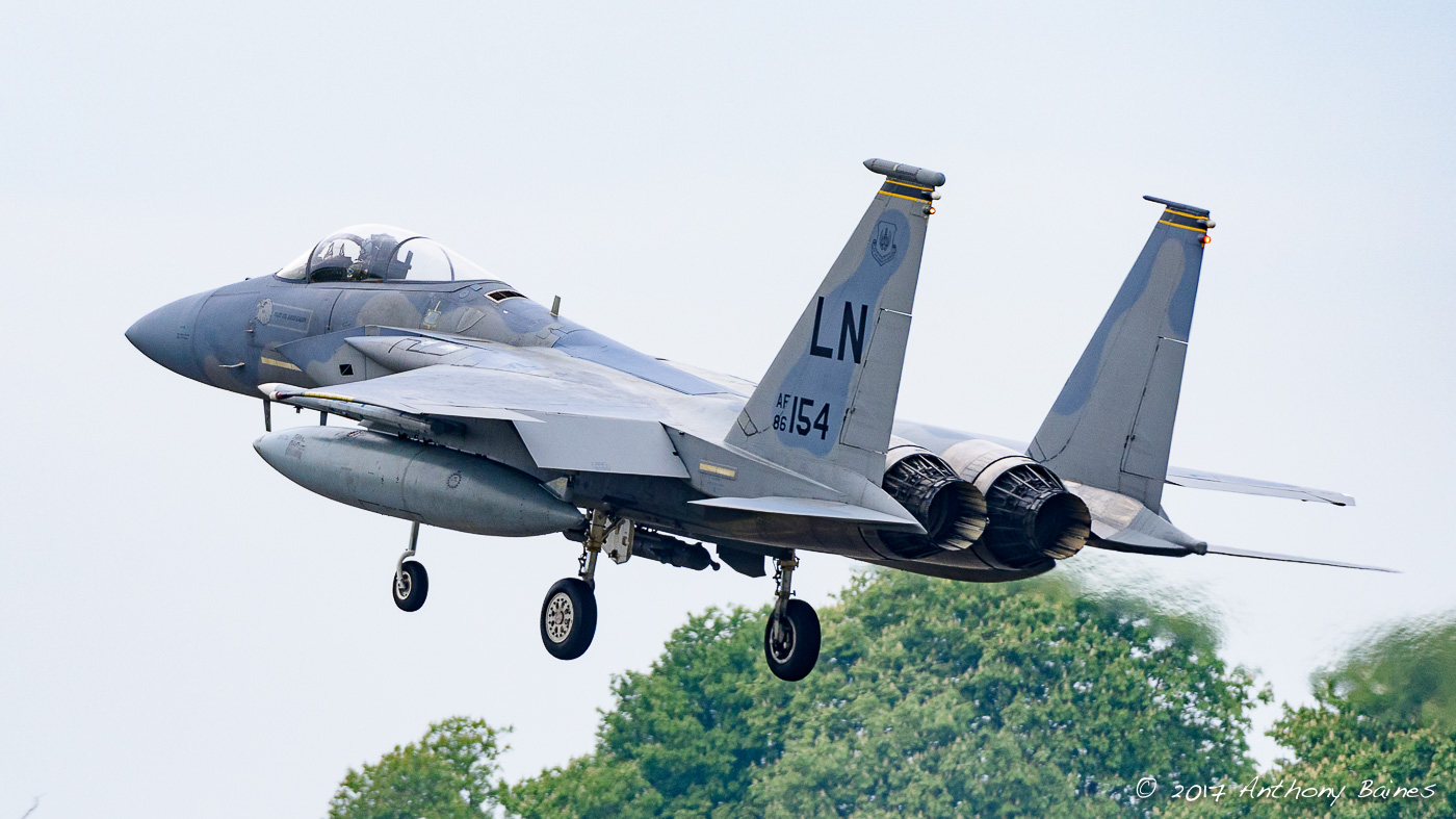 An F-15C Eagle goes over the perimeter fence at Lakenheath