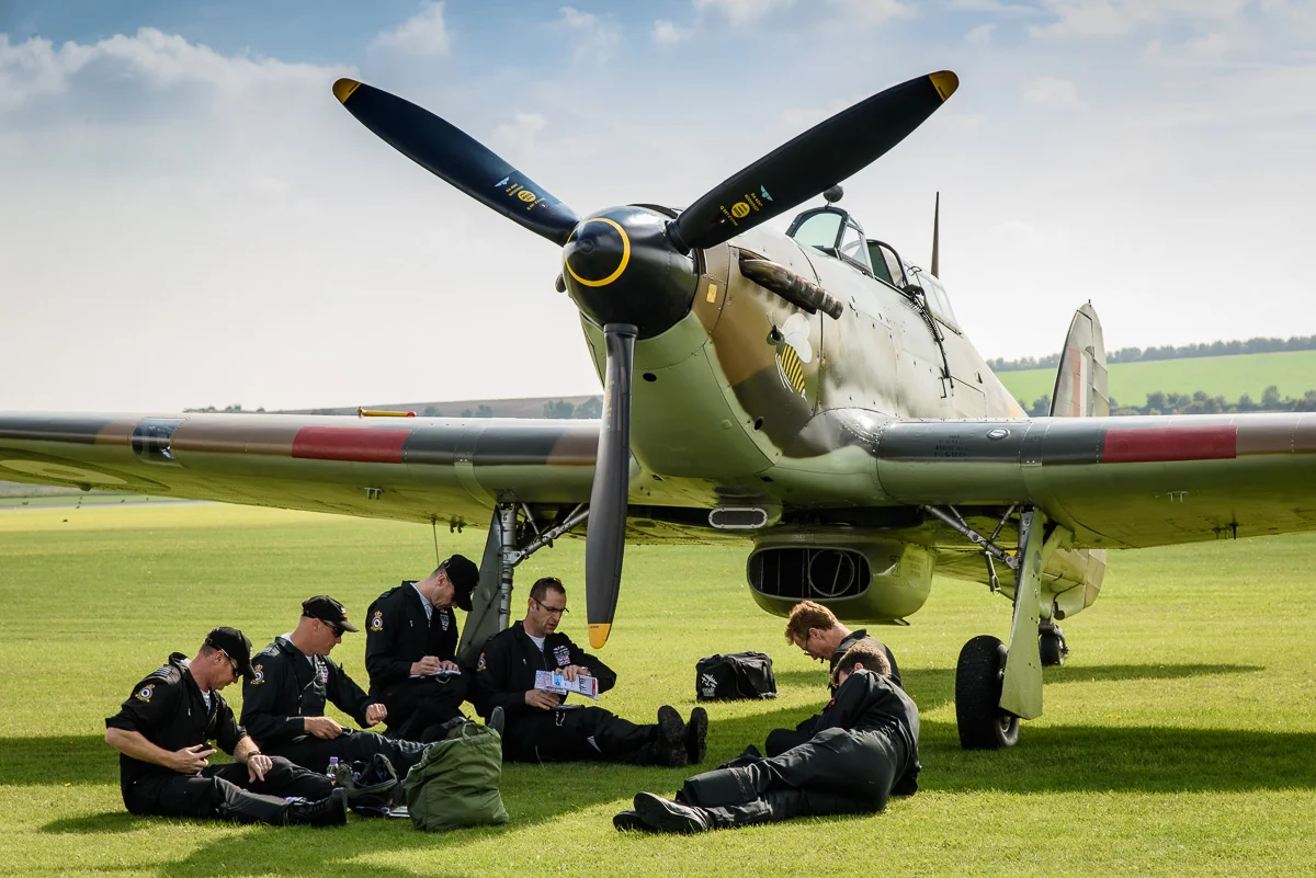 Battle of Britain Memorial Flight briefing. The personnel gather in the shade of one of their aircraft, a Hurricane. Nikon D810, Nikon 24-120mm f/4G, 1/160 sec, f/11, ISO 200, 98.0 mm