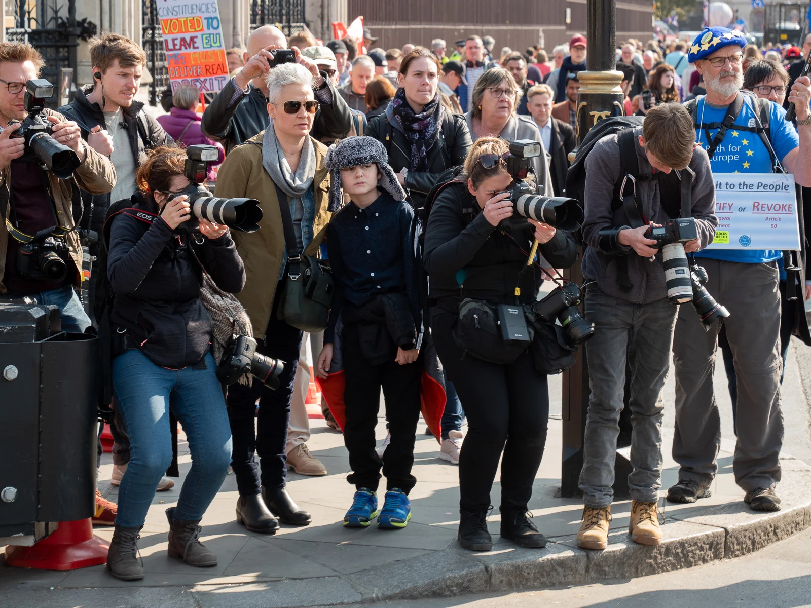Whenever a ministerial car gingerly makes its way through the crowd (they certainly don’t sweep in), photojournalists line up at the kerb to get pictures of the occupants. The flashes are to punch light through tinted windows. Meanwhile, everyone else waits to cross the road.