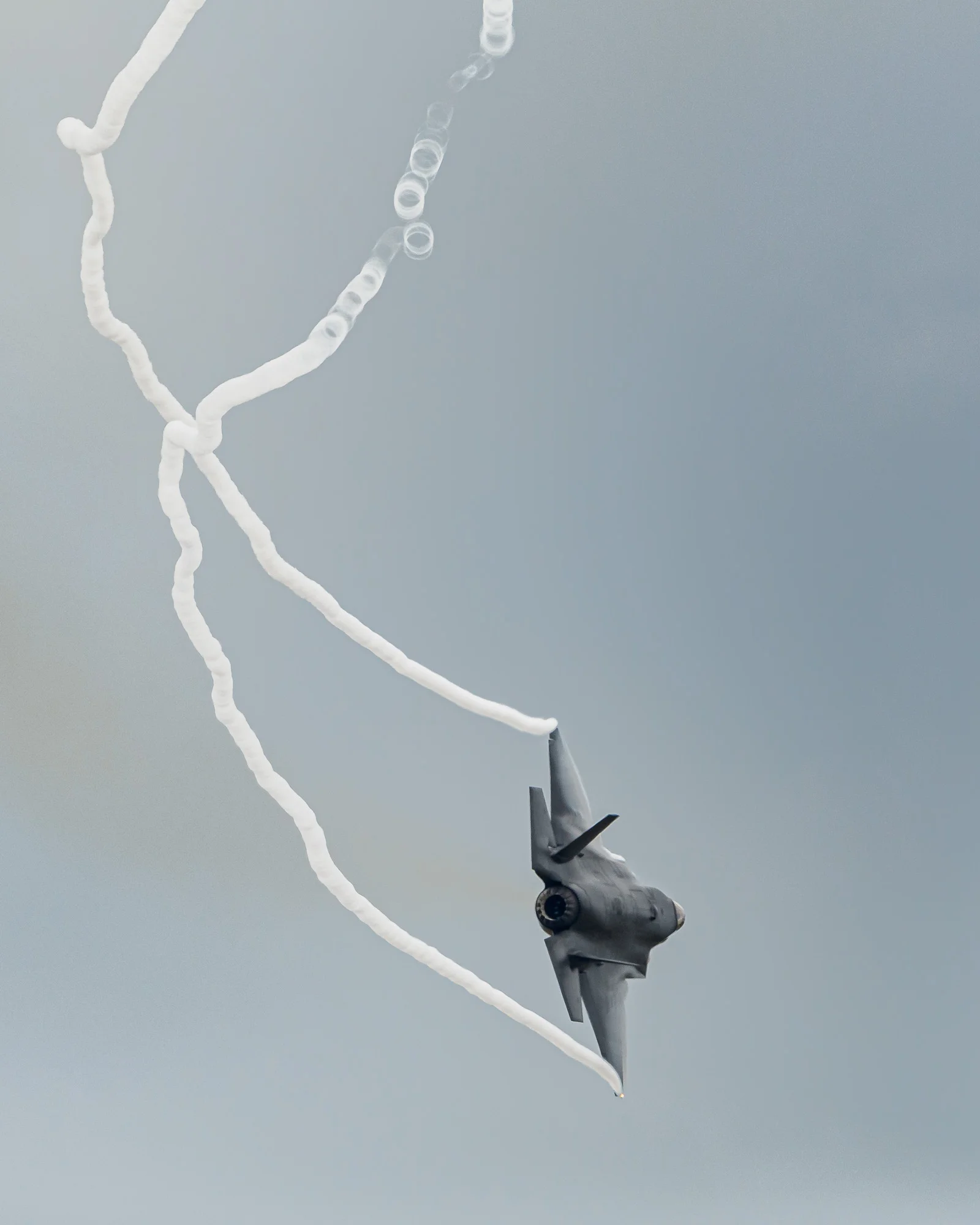 RAF F-35 Lightning-II streaming vapour from its wingtips: the vapour seems to break up into bubbles.