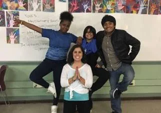 Kayla with three of her students. They are practicing the “tree pose,” which requires standing on one leg. (Photos courtesy of Citizen Schools)