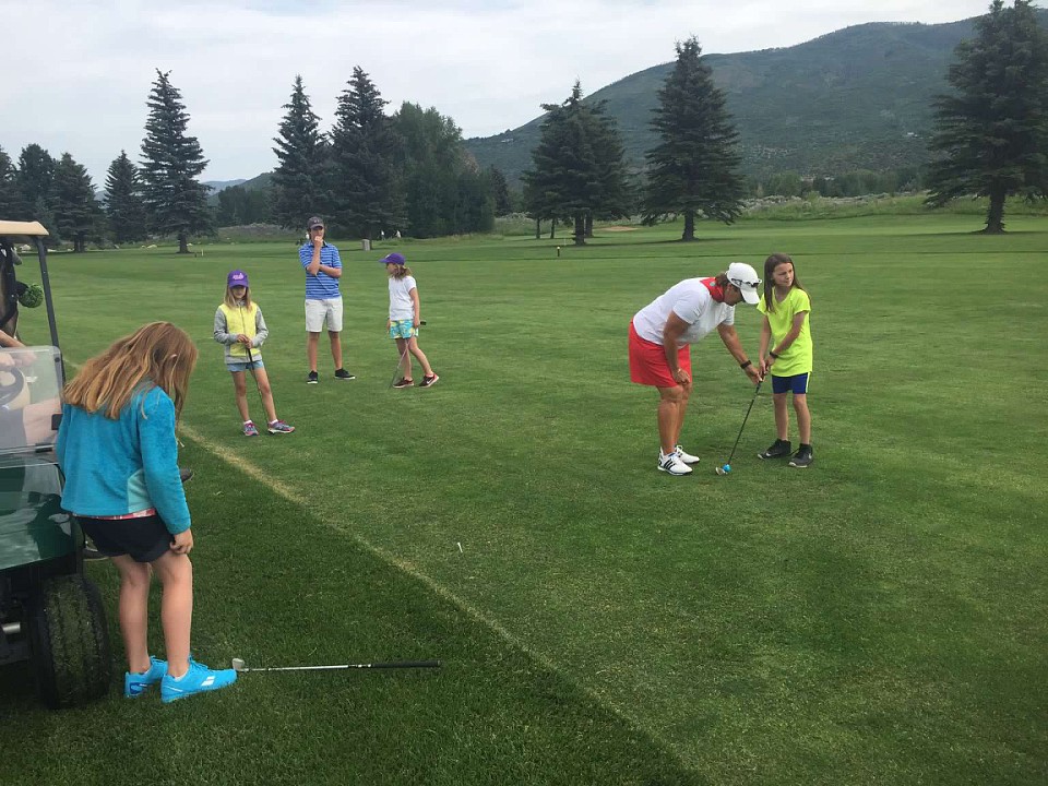 Dede helps with alignment as our girls play some holes on the golf course