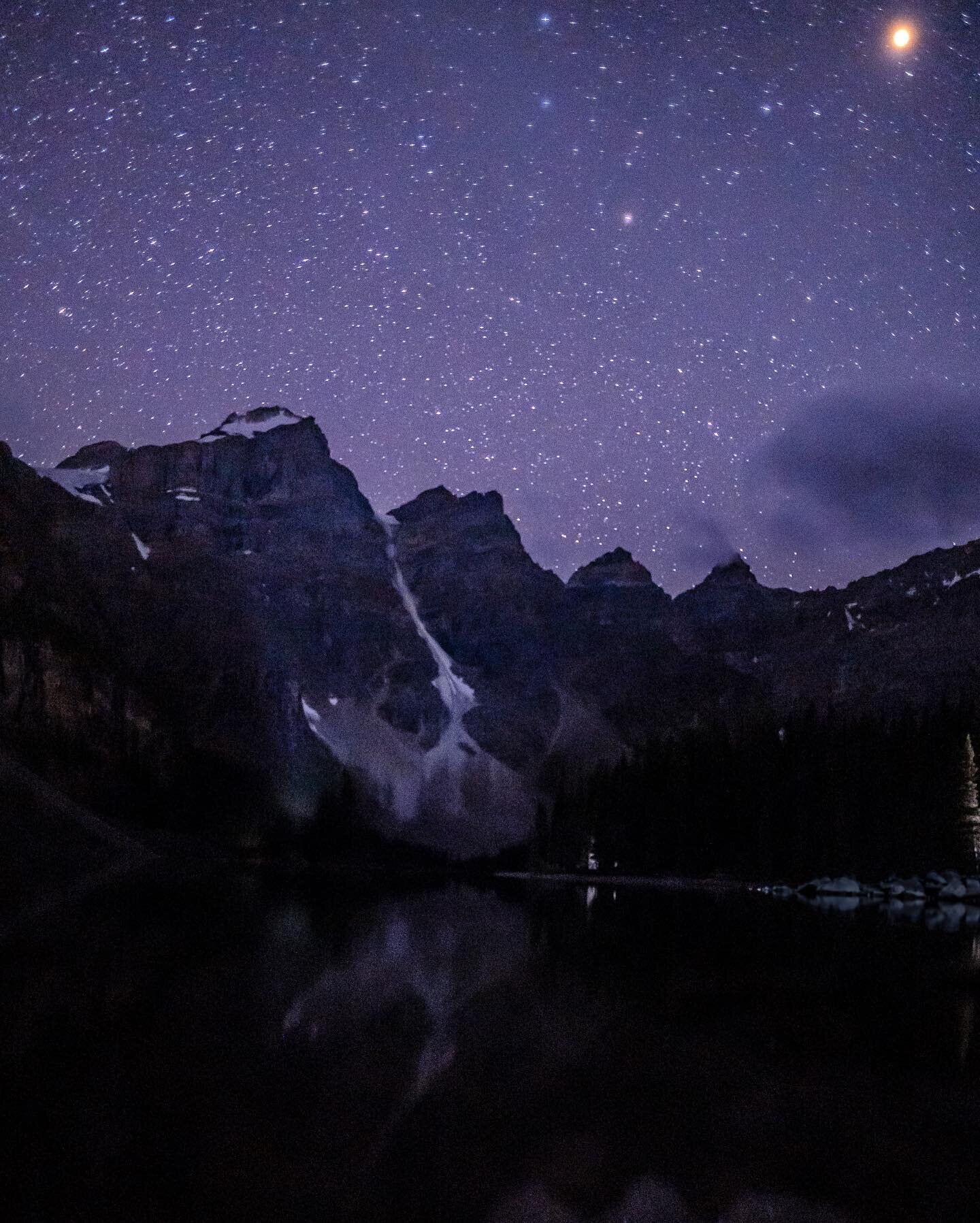 Took this photo at the trailhead for the Larch Valley hike at Moraine Lake, AB. It was pitch black, so I cranked the ISO on my Sony A7iii and placed the camera on a rock to keep it steady. To my surprise, I was able to capture Mars passing by over th
