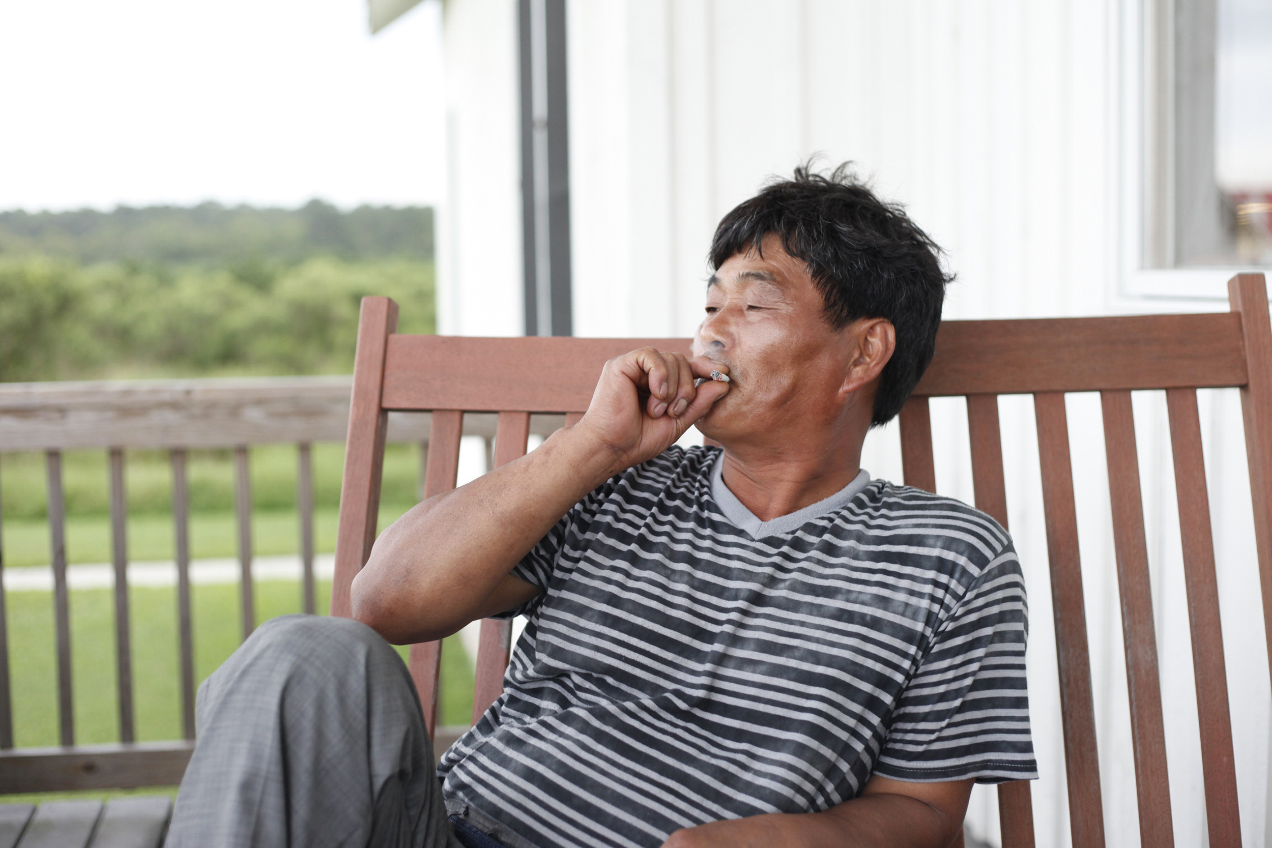 Stanley's father Ki Chang-Sik takes a drag of a cigarette.