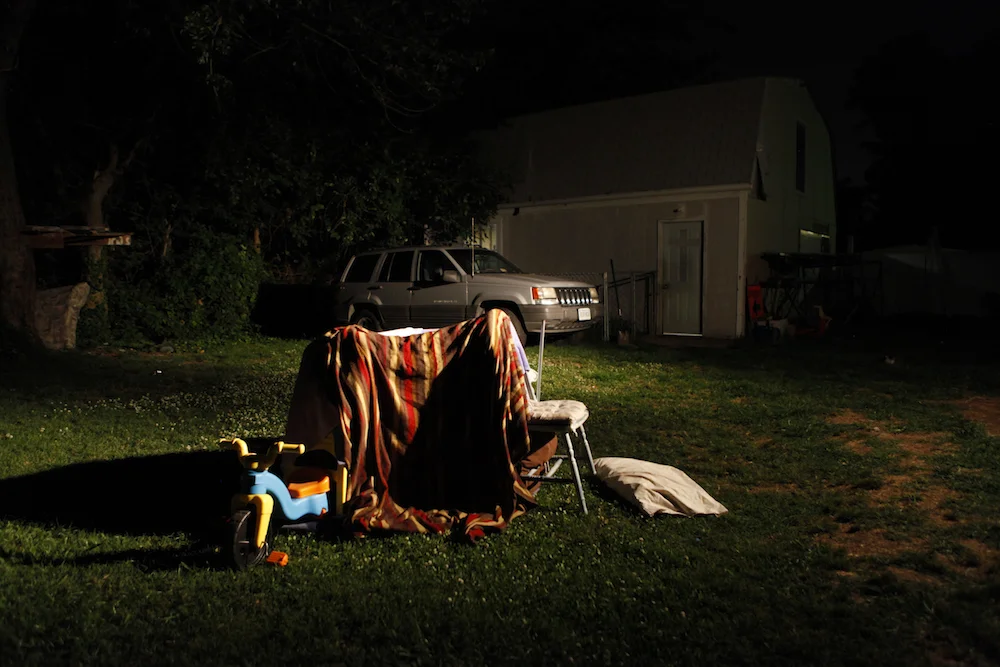 Blankets and chairs create a fort in the yard.