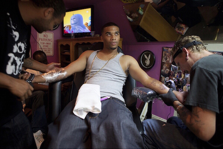 Richie tattoos a customer.