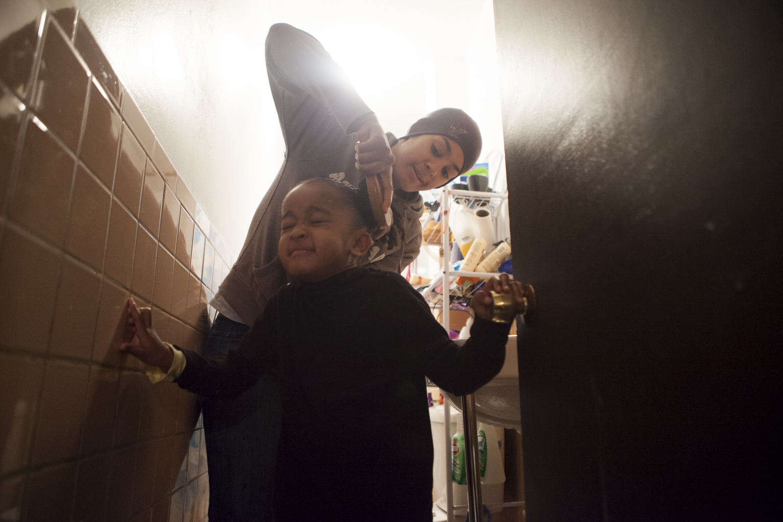 Calise Hawkins brushes back her daughter Asha Hawkin's hair.