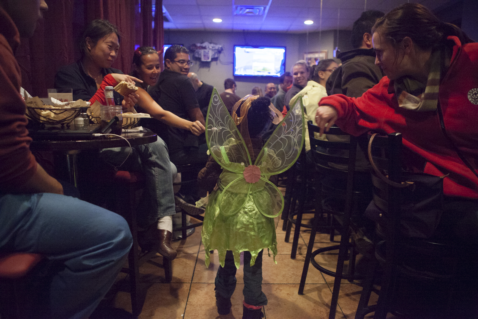 Asha enters a packed bar. Patrons offer her candy.