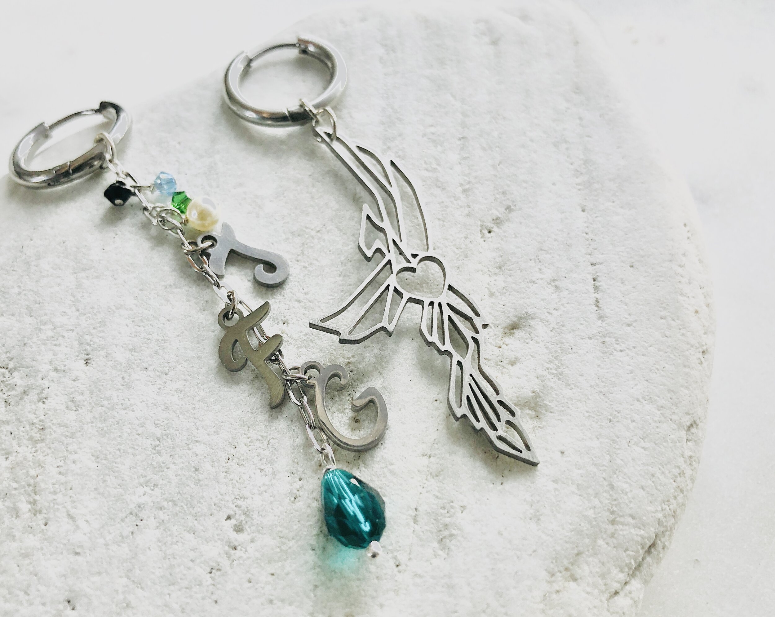 不對稱鳳凰耳環-一邊心型鳳凰一邊TFG字母水晶垂墜；stainless silver NTD2400；gold version NTD2900