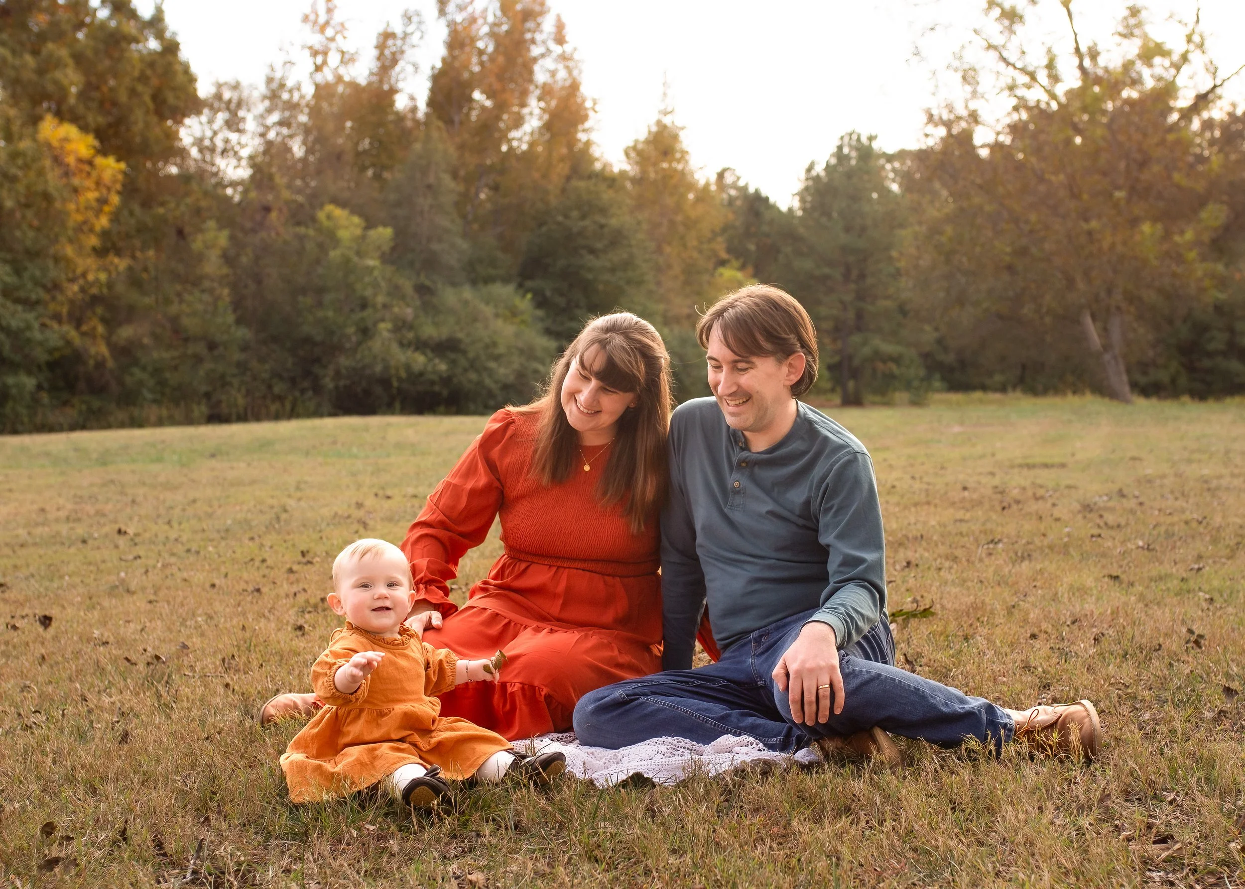 family of 3 in park sitting joyner wake forest.jpg