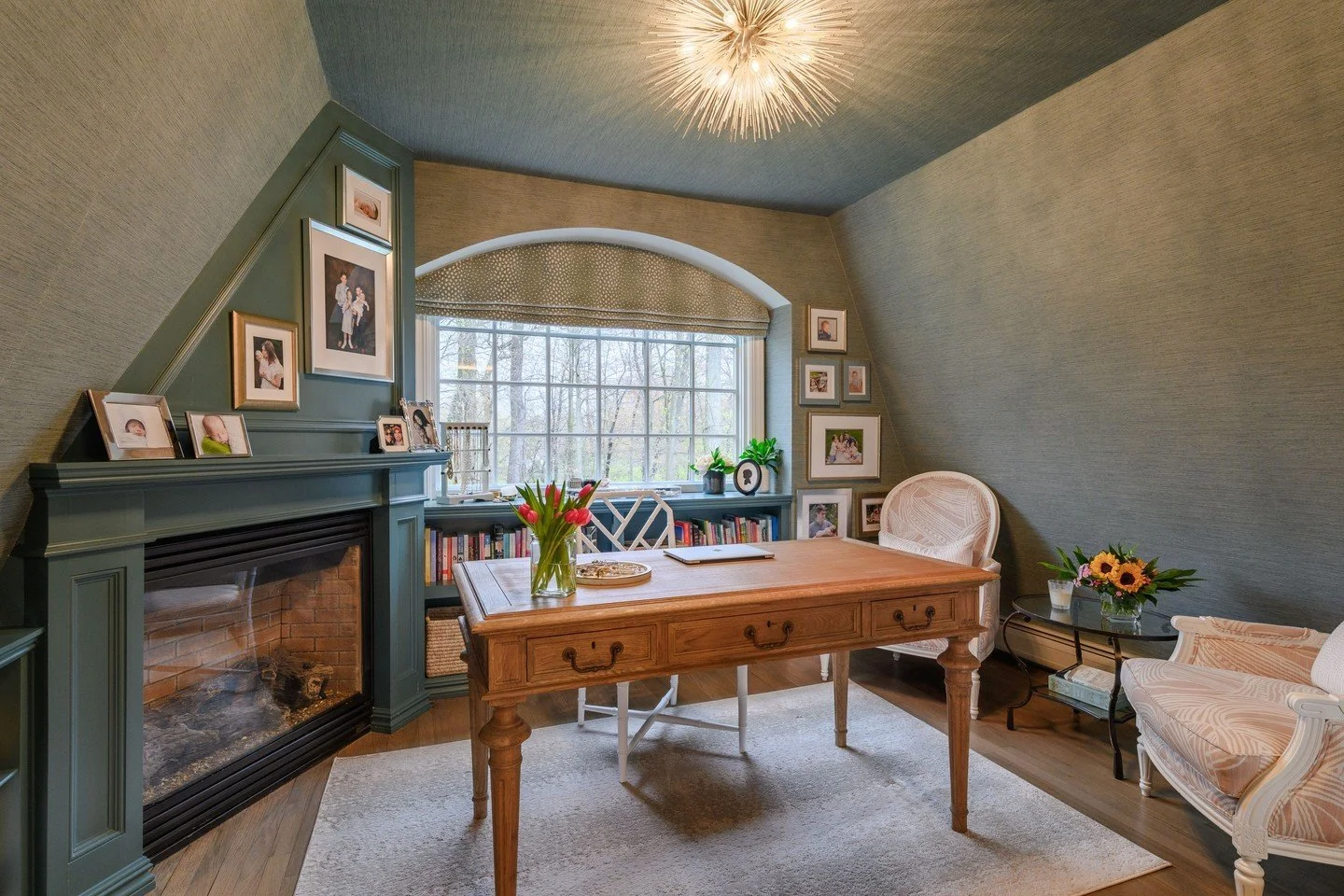 I picture all of my favorite authors writing in this home office. While slanted ceilings can sometimes cause a challenge this design thrived from them. This home office artfully balances warmth and functionality, with a fireplace anchoring the space 
