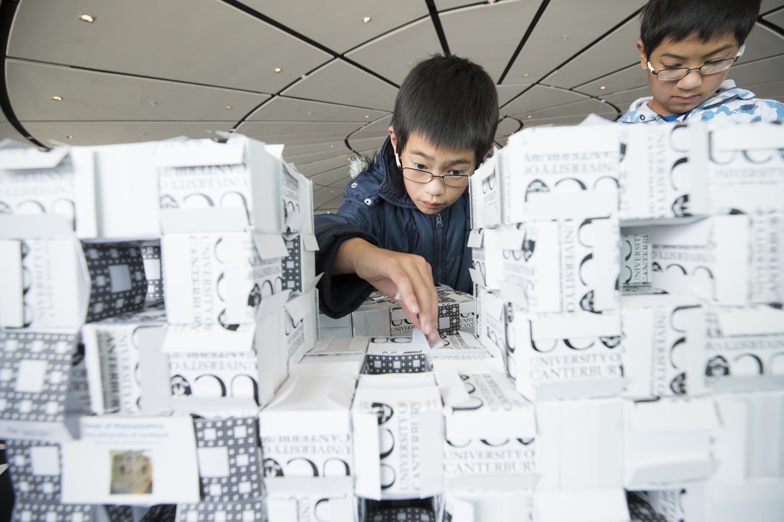 Two children working on a large Menger sponge at the Auckland Maths Craft Festival (Copy)
