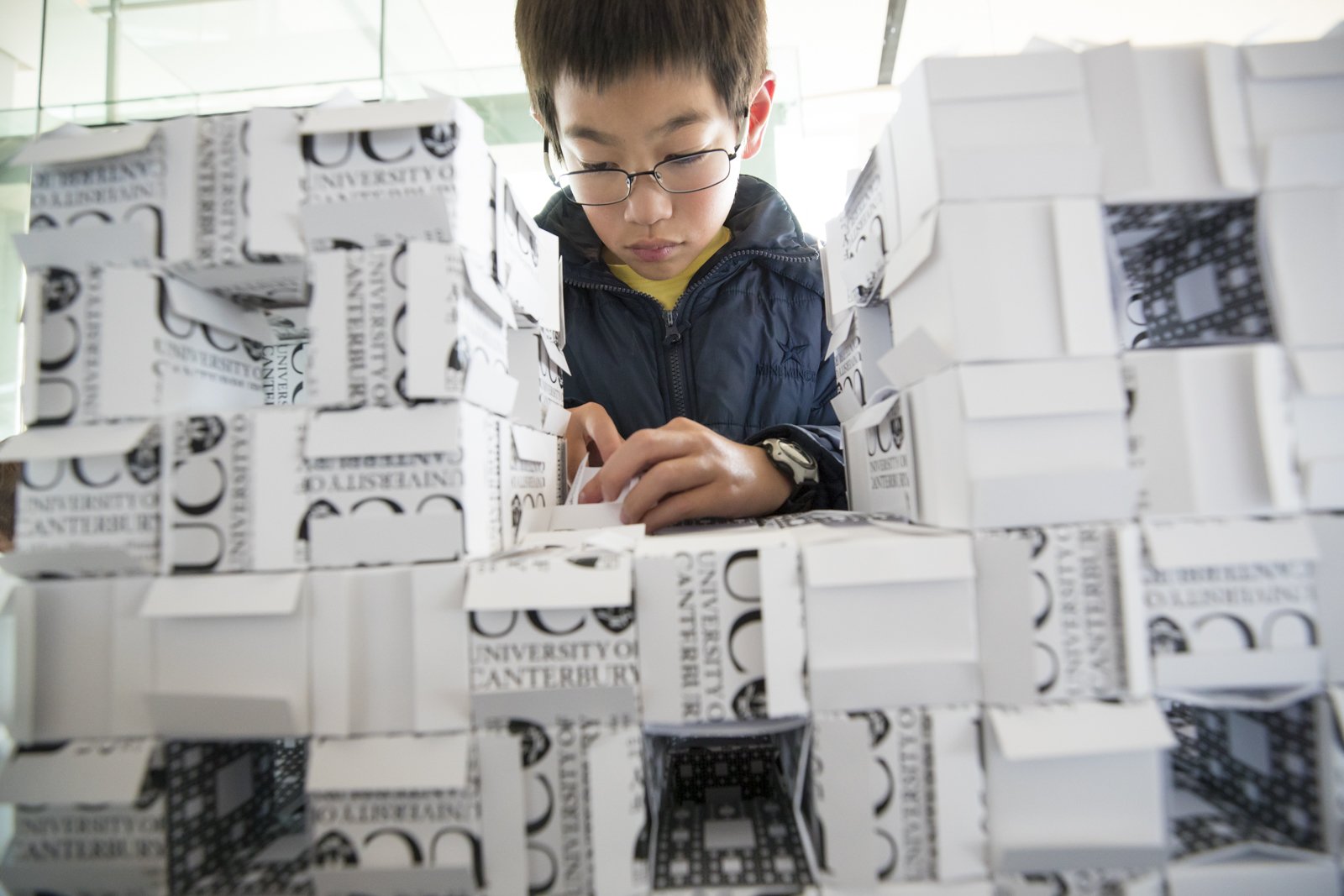 A child working on a large Menger sponge at the Auckland Maths Craft Festival (Copy)