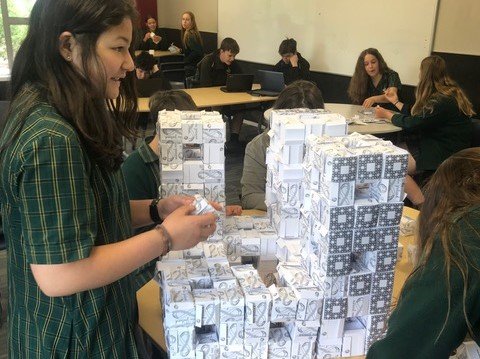 Students in a classroom working on a large Level 2 Menger sponge (Copy)