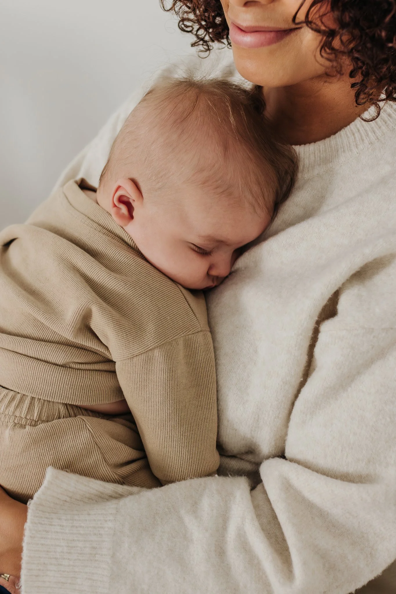 A baby sleeps on a woman's chest.