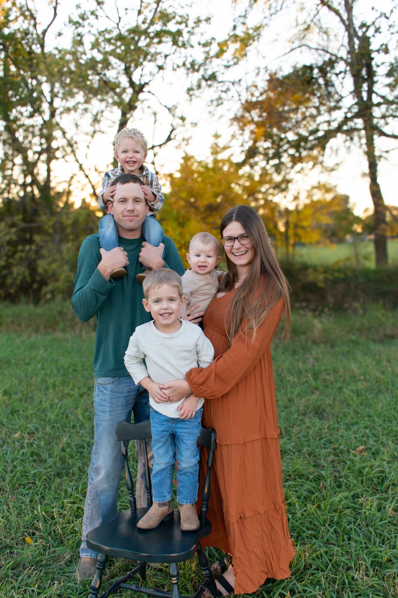 Photo of doula Kristin Grosz and her three sons and husband with trees behind them.
