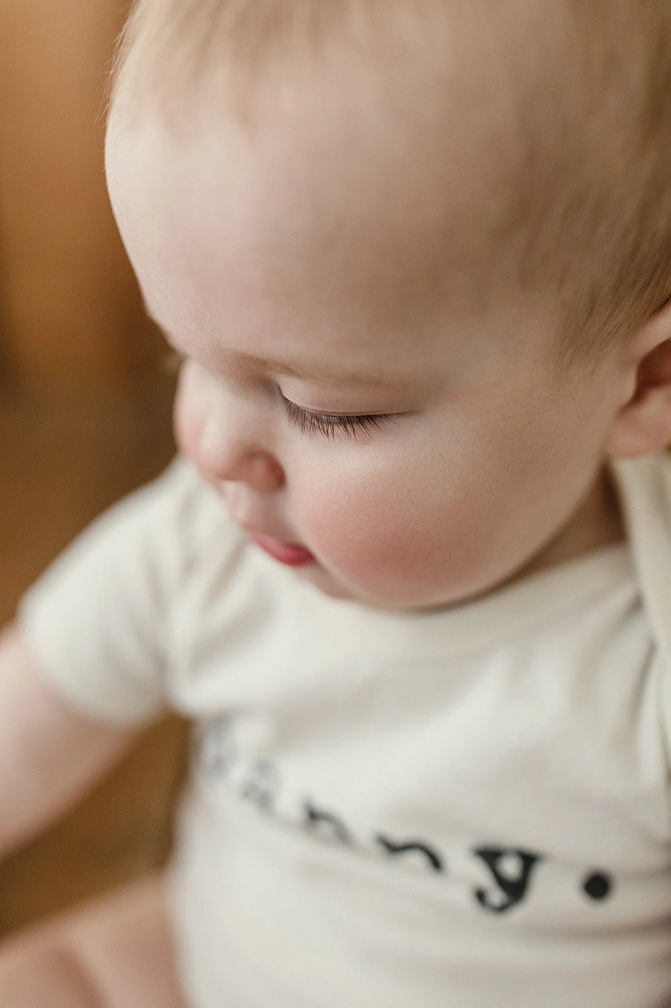 Close-up of a young child's face, showing blond hair, closed eyes, and soft pink cheeks during photos at the Ally and B Photography studio in downtown Naperville, IL.
